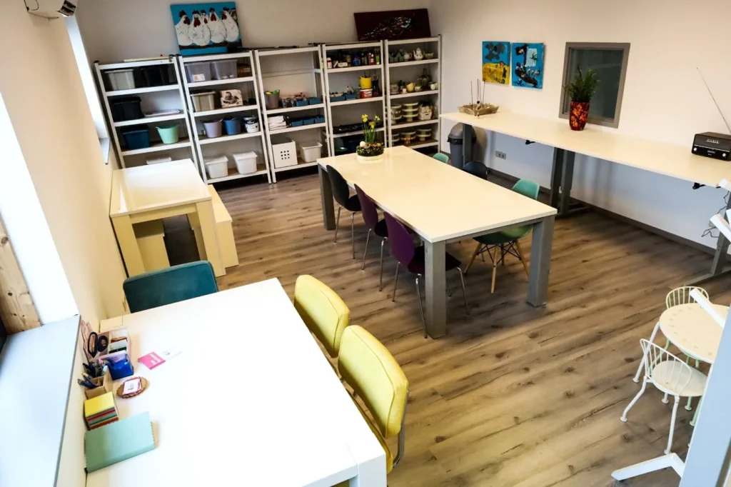 Het lichte atelier van De Creatieve Zolder met werktafels en kasten vol materiaal