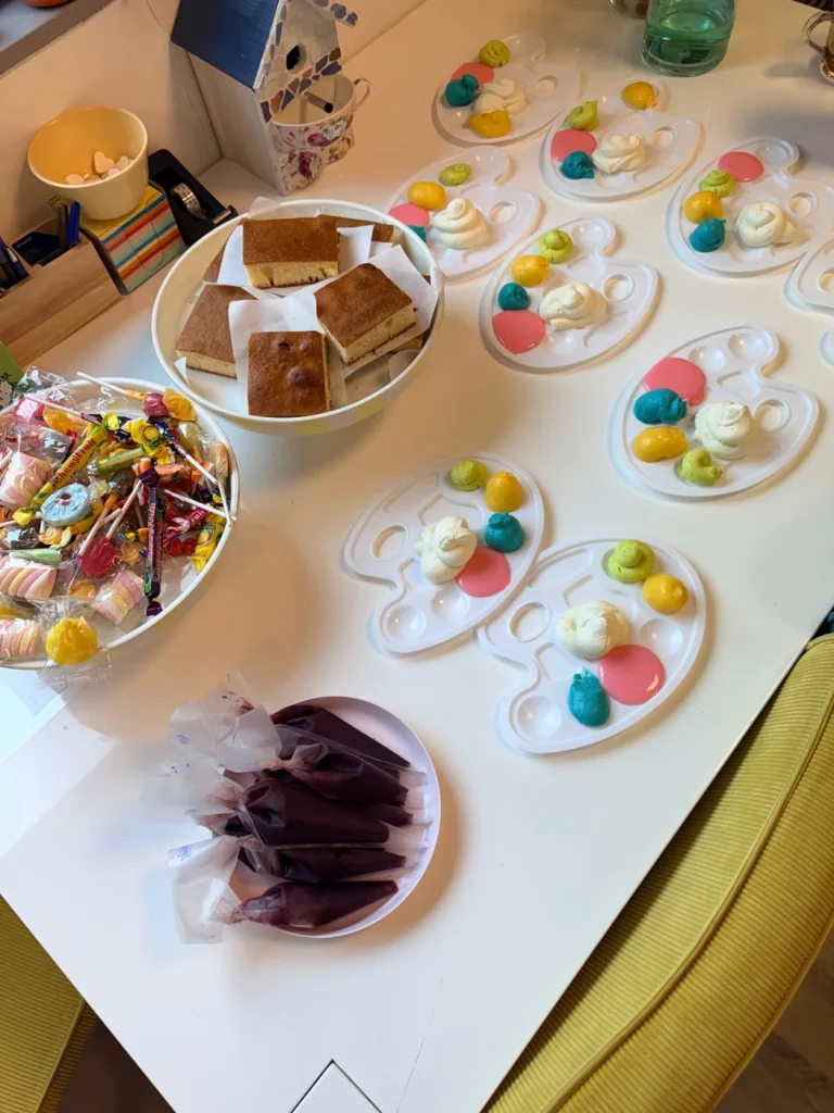 Tafel klaar voor een kinderfeestje met cakejes, verf en snoep