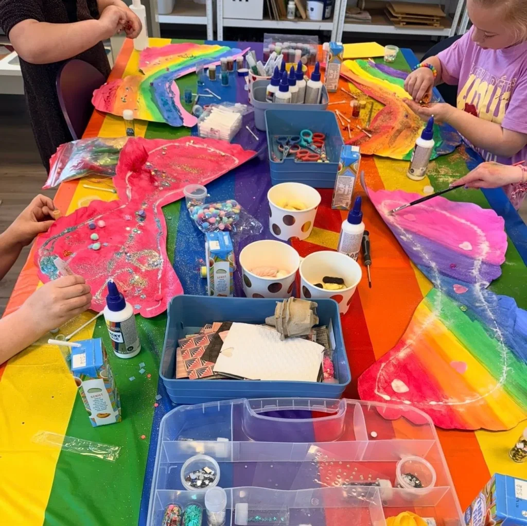 Kinderen knutselen aan een kleurrijke tafel vol verf en lijm