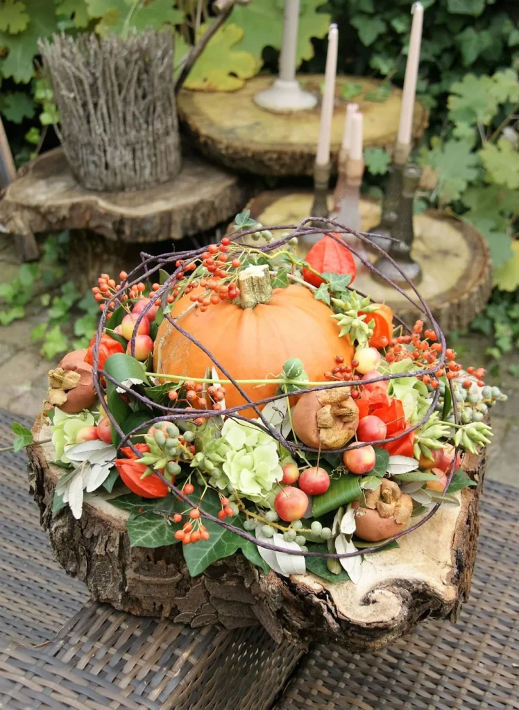 Herfststuk met pompoen, rozen en besjes op een boomschijf